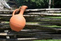 Clay jug on wicker fence