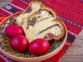 Clay plate with slices of traditional easter sweet bread or cozonac and red painted eggs, romanian tradition Royalty Free Stock Photo