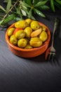 Clay pot with artisan olives preserved in extra virgin olive oil, vinegar, spices with red peppers and garlic. Royalty Free Stock Photo