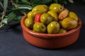 Clay pot with artisan olives preserved in extra virgin olive oil, vinegar, spices with red peppers and garlic. Royalty Free Stock Photo