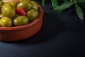 Clay pot with artisan olives preserved in extra virgin olive oil, vinegar, spices with red peppers and garlic. Royalty Free Stock Photo