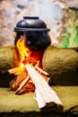 A clay pot cooking and heated over a wood fired stove made out o Royalty Free Stock Photo