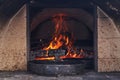 Clay pot and frying pan with meat stands in a Russian oven on an open fire on wood, stewed roast. Rustic authentic food.