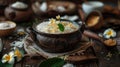 Clay pot with Kiribath on a rustic table, surrounded by coconut milk, rice, and frangipani flowers for Sinhalese New