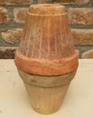 Clay pot placed upside down on anther pot. aged terracotta pots