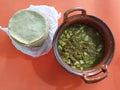 Clay pots filled with pork rinds in green sauce and tortillas, traditional Mexican food