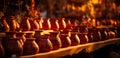 Clay pots sitting on shelves in a pottery workshop. A row of red vases sitting on top of a table