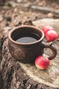 Clay Rural Cup with Hot Beverage and red apples on Wooden Stub.