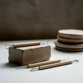Clay sculpting setup with a solid block of clay on a table. Three sculpting tools