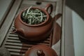 Clay tea pot with portion of white tea on a wooden table close-up Royalty Free Stock Photo