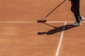 Clay tennis court preparation after match. Cleaning surface orange sport ground for game. Sport background, copy space Royalty Free Stock Photo