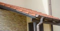 Clay tiled house roof with rain gutter under entrance home door