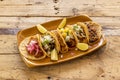 Clay tray with assorted Mexican tacos of cochinita pibil, pastor tacos, lime,