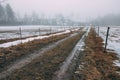 Clayey forest road between two horse paddocks Royalty Free Stock Photo