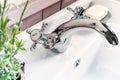 Clean bathroom sink with silver modern faucet, white soap and brown pill bottle