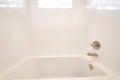 Clean bathroom with sparkling built in bathtub and shiny white tiles in the wall Royalty Free Stock Photo