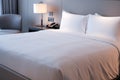 Clean Bedding sheets and pillow on natural wall room background. White bedding and pillow in hotel room. White pillows on bed.