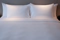 Clean Bedding sheets and pillow on natural wall room background. White bedding and pillow in hotel room. White pillows. Royalty Free Stock Photo