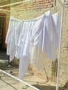 Clean bedsheet hanging on a clothesline at the street.