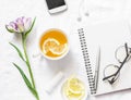 Clean blank notebook, green tea with lemon, tulip flower on white background, top view. Flat lay Royalty Free Stock Photo