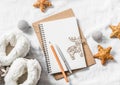 Clean blank notepad, christmas ornaments, wooden reindeer, toys, home ugg boots on a light background, top view