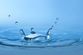 Clean blue drop of water splashing in clear water Royalty Free Stock Photo