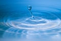 Clean blue drop of water splashing in clear water Royalty Free Stock Photo