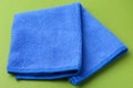 Clean blue microfiber cloth on green background, closeup Royalty Free Stock Photo