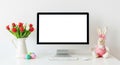Easter desktop setup with tulips computer and bunny decoration monitor screen Royalty Free Stock Photo