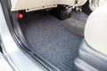 Clean car floor mats of black carpet under front passenger seat in the workshop for the detailing vehicle before dry cleaning.