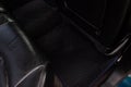 Clean car floor mats of black rubber under rear passenger seat in the workshop for the detailing vehicle dry cleaning. Auto Royalty Free Stock Photo