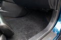 Clean car floor mats of black rubber under rear passenger seat in the workshop for the detailing vehicle dry cleaning. Auto Royalty Free Stock Photo