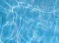 Clean clear blue swimming pool water surface with sunlight reflections and soft ripple waves, abstract summer background texture Royalty Free Stock Photo