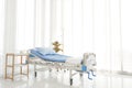 Clean and clear empty hospital near sunny window, blue bed linen with white curtain in ward room for background. Royalty Free Stock Photo