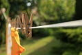 Clean clothes drying outdoors during sunny day, focus on laundry line with wooden clothespins Royalty Free Stock Photo