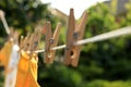Clean clothes drying outdoors during sunny day, focus on laundry line with wooden clothespins Royalty Free Stock Photo