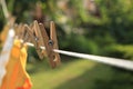 Clean clothes drying outdoors during sunny day, focus on laundry line with wooden clothespins Royalty Free Stock Photo