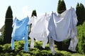 Clean clothes hanging on washing line in garden. Drying laundry Royalty Free Stock Photo