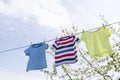 Clean clothes on rope outdoors on laundry day. Colorful t-shirts hanging on a laundry line against blue sky Royalty Free Stock Photo