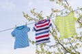 Clean clothes on rope outdoors on laundry day. Colorful t-shirts hanging on a laundry line against blue sky Royalty Free Stock Photo