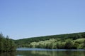 Clean cold spring lake among hills covered with forests in Russian remote place on a summer day. Outdoor. Tourist routes of Russia Royalty Free Stock Photo