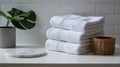 Stack of fresh white towels with plant in bright bathroom setting Royalty Free Stock Photo