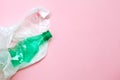 Clean crumpled green plastic water bottle and white plastic bag ready for recycling isolated on pink background, top view Royalty Free Stock Photo