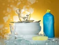 Clean dishes and cups, dishwashing detergent and sponge on a yellow in soap bubbles