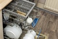 Clean dishes, cups, spoons and forks in a dishwasher at home kitchen