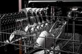 Clean dishes in the dishwasher. Wine glasses, glasses, cups. Close-up. Washing-up and housework concept Royalty Free Stock Photo