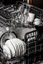 Clean dishes in the dishwasher. Wine glasses, glasses, cups, plates, cutlery. Close-up. Washing-up and housework concept. Vertical Royalty Free Stock Photo