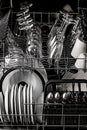 Clean dishes in the dishwasher. Wine glasses, glasses, cups, plates, cutlery. Close-up. Washing-up and housework concept. Vertical Royalty Free Stock Photo