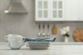 Clean dishware on white table in kitchen, space for text Royalty Free Stock Photo