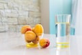 Clean drinking water in a glass, a bowl of apricots on the table. Royalty Free Stock Photo